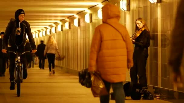 A young girl street musician plays the violin in an underpass tunnel — Stock Video