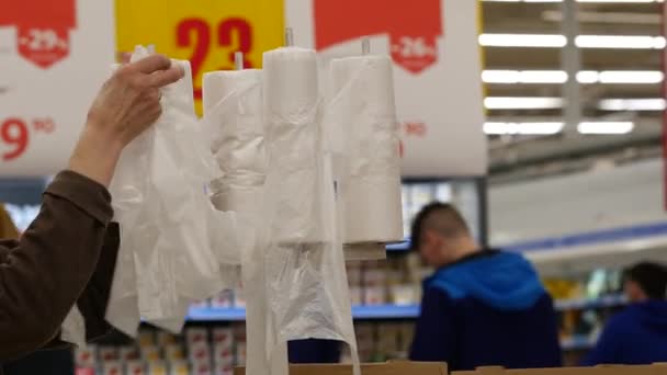 Женщина берет тонкую прозрачную упаковку пластиковый пакет для овощей . — стоковое видео