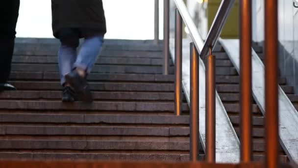 Voeten van mensen die uit de onderdoorgang komen. Zicht van onderen en vooraan. Schemering. — Stockvideo