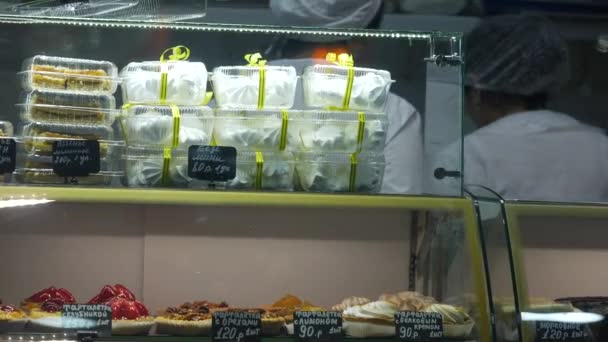 Brownies in glazen bakkerij vitrine. Onherkenbaar personeel in witte schorten en hoeden — Stockvideo