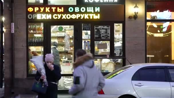 Las mujeres dejan la tienda de frutas secas. La gente pasa por una pequeña tienda de dulces . — Vídeos de Stock