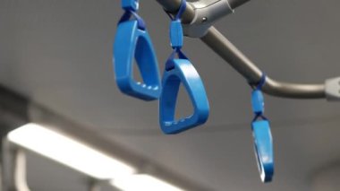 Plastik mavi kulplar Moskova Merkez Halkası 'nın arabalarında naylon kemerlere asılıyor. Kulplar metro treniyle tam zamanında takılıyor. Toplu taşıma. Şehirdeki demiryolunu bağlayın.