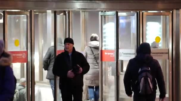 Moscou, Russie - 26 novembre 2019 : Les gens sortent des portes vitrées de l'entrée du métro Timiryazevskaïa. Parois en verre d'une structure éclairée. Les passagers quittent le métro le soir — Video