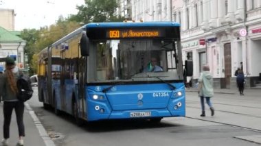 Otobüs duraktan kalkıyor. Şehirde toplu taşıma. Mavi modern otobüs ile