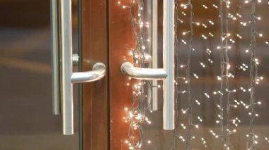 Minyatür ampullerden oluşan çelenkler vitrin camının yanında parlıyor. Ziyaretçiler geldi.