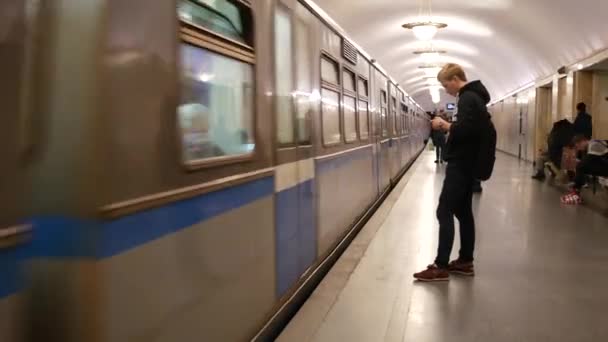 Folk står på tunnelbaneplattformen och väntar på att tåget ska stoppa ankomsten. — Stockvideo