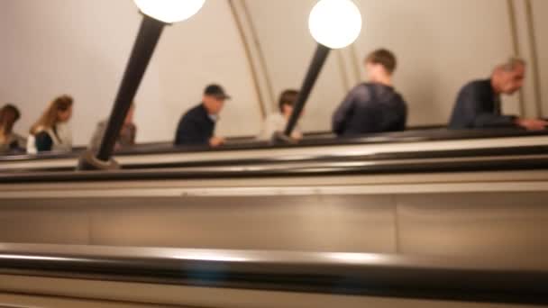 Unrecognizable metro passengers on an escalator. People with blurry faces rise — Stock Video