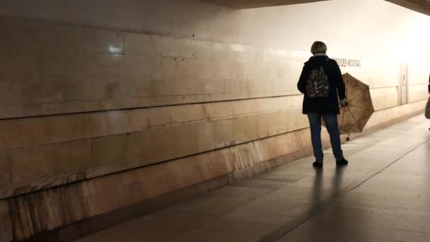 Frau steht mit geöffnetem Schirm auf Bahnsteig der U-Bahn und dreht sich — Stockvideo