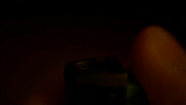 Mão masculina com um isqueiro de gás no escuro. À noite, um homem acende uma chama — Vídeo de Stock