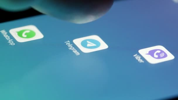 Lancering van Telegram applicatie. Iemand raakt smartphone scherm per vinger aan — Stockvideo