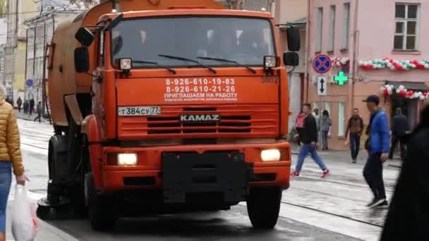 Eine Kehrmaschine mit rotierendem Pinsel fährt die Straße entlang und kehrt. — Stockvideo