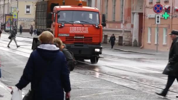 Oranžový zavlažovací stroj projíždí ulicí. Vodní trysky vyrazily na cestu. Vozidlo — Stock video