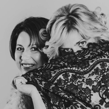 Kız kardeşler sarılıp dantelden bakar. Yüzü dantelle kaplıydı.