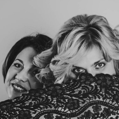 Kız kardeşler sarılıp dantelden bakar. Yüzü dantelle kaplıydı.