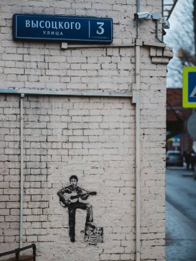 Moskova, Rusya - 17 Ocak 2020: Vladimir Semenovich Vysotsky 'nin müze evinin tuğla duvarında gitar ve teyp ile Visotsky' nin resmi - Sovyet şair, tiyatro ve film oyuncusu, söz yazarı