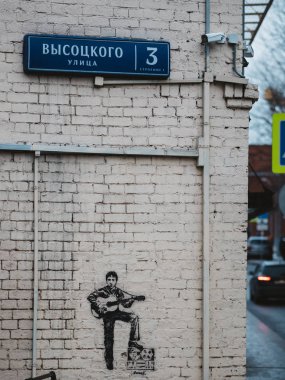 Moskova, Rusya - 17 Ocak 2020: Vladimir Semenovich Vysotsky 'nin müze evinin tuğla duvarında gitar ve teyp ile Visotsky' nin resmi - Sovyet şair, tiyatro ve film oyuncusu, söz yazarı
