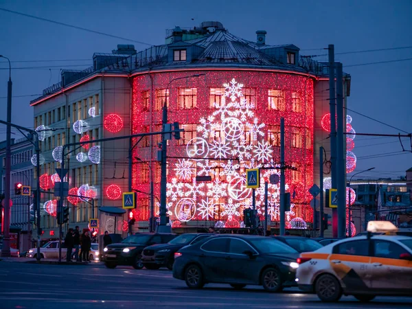 Moscow, Russia - January 17, 2020: Festive New Year's LED illumination on the facade of the building on Taganskaya Square. Cars drive along the road at dusk. Bright backlight with design solutions — 스톡 사진