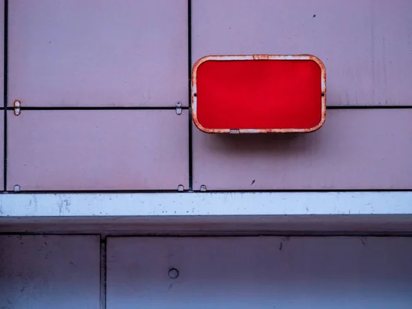 Röd industriplåt med ljus på väggen i byggnaden ovanför ingången till källaren. Hitta på en tom mall för din text eller bild. — Stockfoto