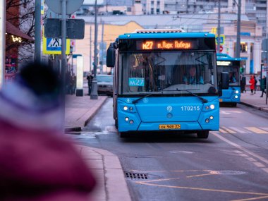 Moskova, Rusya - 17 Ocak 2020: Mavi M27 otobüsü bir toplu taşıma durağına yanaştı. Otobüsleri olan şehir caddesi. Trafik güzergahı hakkında makine bilgisinin öncülüğünde