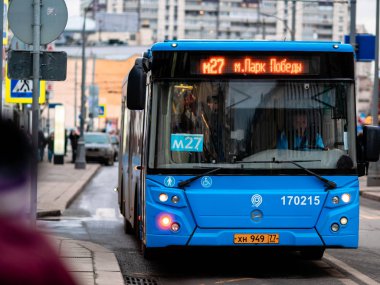 Moskova, Rusya - 17 Ocak 2020: Mavi M27 otobüsü bir toplu taşıma durağına yanaştı. Otobüsleri olan şehir caddesi. Trafik güzergahı hakkında makine bilgisinin öncülüğünde
