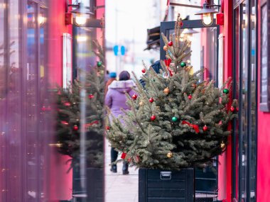 Şehirde oyuncakları ve çelenkleri olan bir Noel ağacı. Rusya, Moskova 'da bir restoranın girişinde çok renkli cam topları olan Noel ağacı. Toplu taşıma durağının camındaki yansıma..