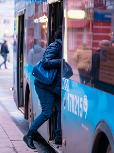 モスクワ、ロシア- 2020年1月17日:青いM27バスは公共交通機関の停留所まで運行しています。バスで街の通り。女がドアに入る — ストック写真