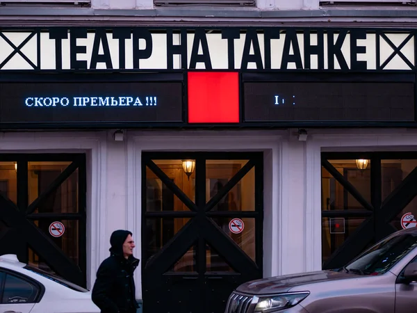 Moscow, Russia - January 17, 2020: Sign at entrance to theater. Building of Taganka Theater. A man walks under a sign with an LED running line. The text on the scoreboard - Coming soon. Parked cars — Stock Photo, Image