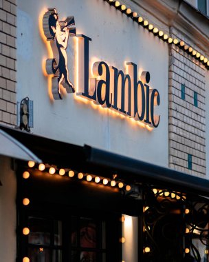 Moscow, Russia - January 17, 2020: Lambic sign above the entrance to a street restaurant in the city. Backlight from many light bulbs in the evening clipart