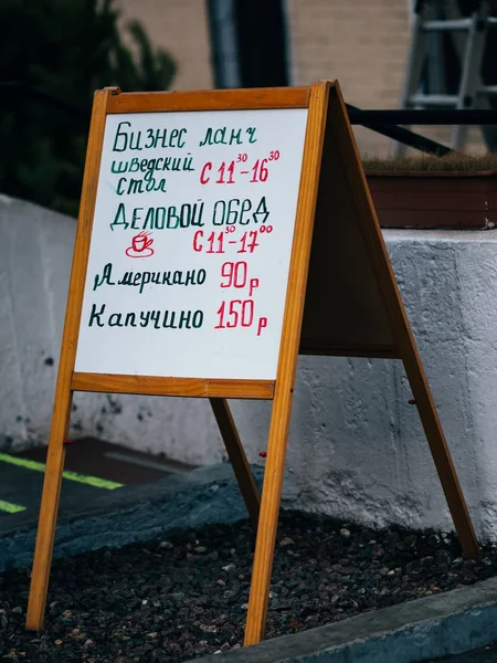 Moscow, Russia - January 17, 2020: Wooden street stand with a white chalk board for inscriptions. Restaurant menu in russian language. Outdoor advertising — Stock Photo, Image