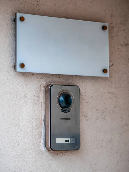 Un cartel en la pared del edificio y un botón de llamada para el personal. Placa rectangular blanca con una campana y cctv intercomunicador. En blanco para tu mensaje. Mockup plantilla vacía —  Fotos de Stock