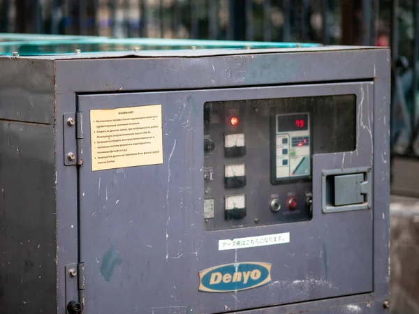 Teckna med inskriptionen Denyo logotyp på en gata elektrisk generator. Autonom tung industriell dieselgenerator. — Stockfoto