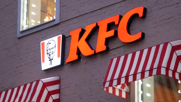 KFC logosu ve gece duvarında kırmızı ışıklar var. Parlak parlak pencereler — Stok video
