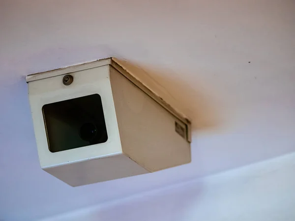 Cámara de vigilancia domo en una cubierta protectora de acero blanco con una ventana transparente. Cámara de video CCTV en el techo blanco en el metro en una caja cerrada con cerradura —  Fotos de Stock