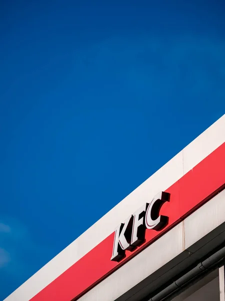 Moscow, Russia - February 8, 2020: Signboard of a fast-food restaurant KFC - an international chain of catering restaurants. Kentucky Fried Chicken logo on a building facade against a bright blue sky. — Stock Photo, Image