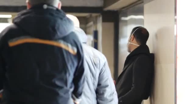 Mężczyzna z maską twarzy klasy N95 w przejściu obok wejścia do metra — Wideo stockowe