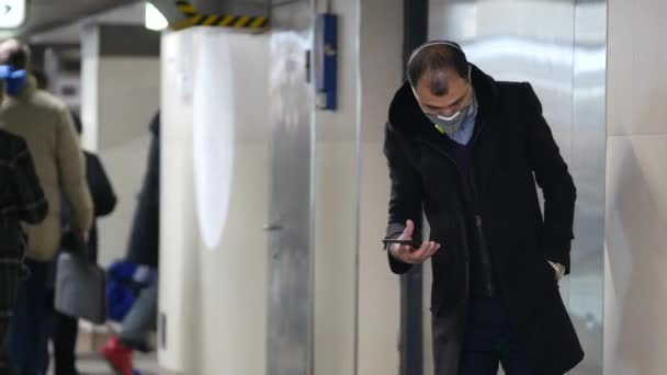 Человек с маской N95 класса в проходе возле входа в метро — стоковое видео