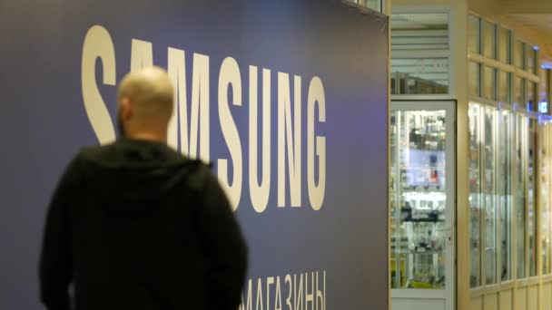 People walk near billboard with inscription SAMSUNG in shopping center — Stockvideo