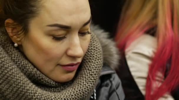Όμορφη κυρία σε χειμερινό σακάκι βόλτες με το μετρό μεταφοράς και κοιτάζει την οθόνη του τηλεφώνου — Αρχείο Βίντεο