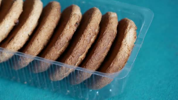 オートミールクッキーは透明なオープンプラスチックトレイにあります 男性の手は甘いルディクッキーを取ります 炭水化物の豊富な食品の過剰摂取や乱用の概念 血糖値を上昇させる血糖値 — ストック動画