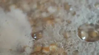Haşlanmış karabuğday tencerede yakın plan. Karabuğday lapası pişiriyorum. Kaynar su