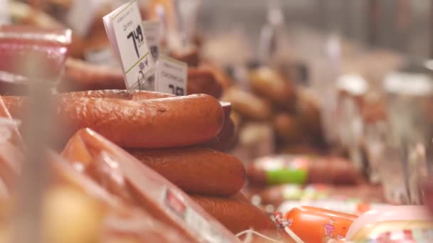 Vitrine du magasin de repas. Derrière le boîtier en verre sont posées des saucisses et autres produits à base de viande — Video