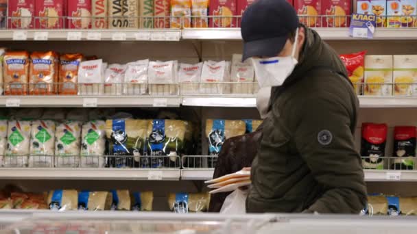 Cliente em respirador de proteção no supermercado Silpo. Homem escolher refeição congelada — Vídeo de Stock