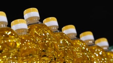 Altın ayçiçeği bitkisel yağıyla dolu şeffaf plastik şişeler.
