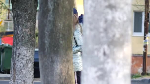 Paar aus Mädchen und Mann trägt Gesichtsmaske auf der Straße am Eingang zum ATB-Geschäft vorbei — Stockvideo