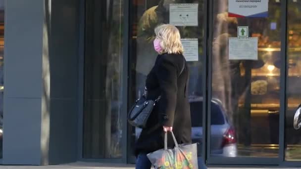 Frau hat Angst vor Covid-19 und trägt Atemmaske oder Mundschutz auf der Straße vor dem Geschäft — Stockvideo