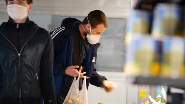 Muž nosí respirátor při nakupování v supermarketu ATB kvůli viru covid-19 — Stock video