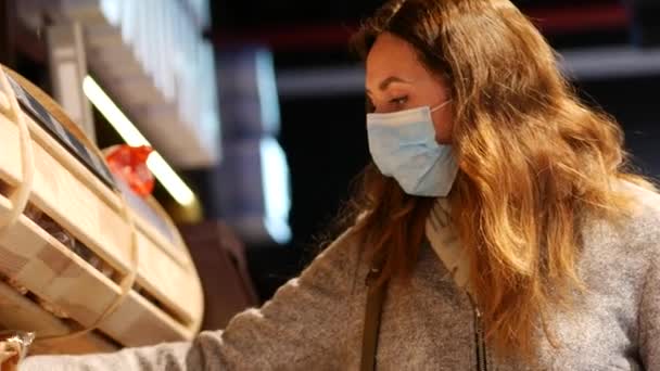 ATB 슈퍼마켓에서 16-19 바이러스 보균자로 쇼핑하는 동안 마스크를 착용하는 여성 — 비디오