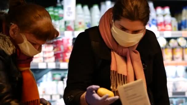 Покупатели надевают маску для лица во время покупок в супермаркете ATB из-за вируса covid-19 — стоковое видео