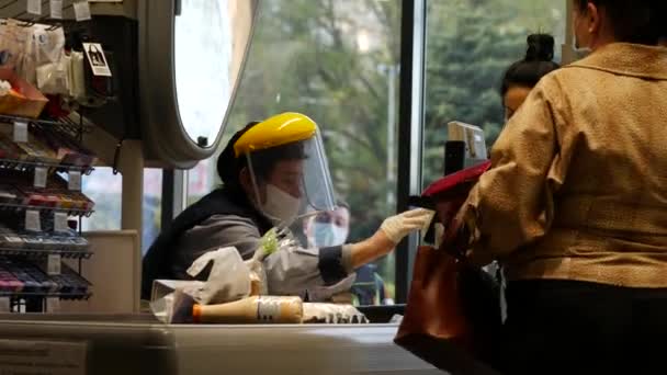 Donna cassiere indossare maschera viso e scudo di vetro nel supermercato ATB A causa di covid-19 — Video Stock