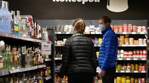 Pareja usa mascarilla facial mientras compras en el supermercado ATB debido al virus covid-19 — Vídeos de Stock